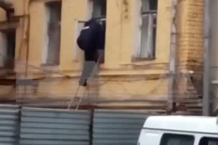Пролезающий в окно полицейский начальник в элитном районе Москвы попал на видео