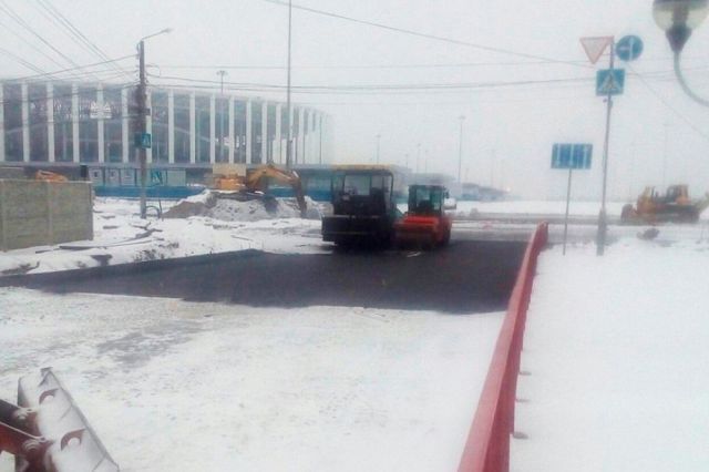 Дорожные рабочие положили асфальт на свежий снег